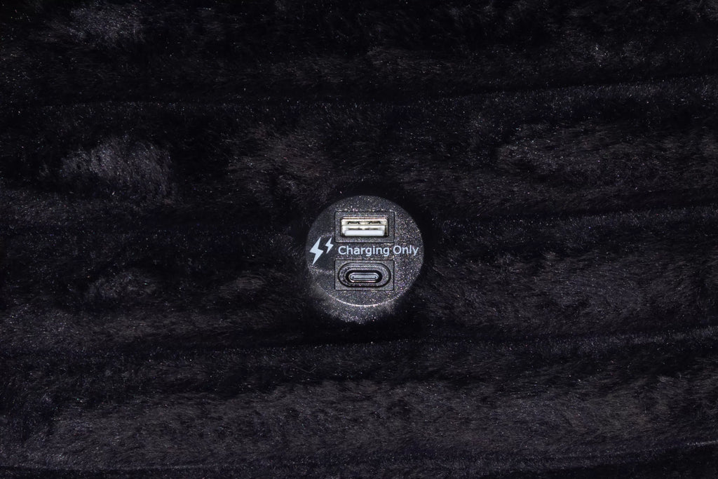 Close up of usb charger on black couch.