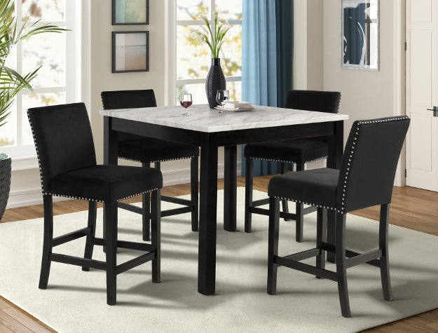 Dining room with a marble table and black chairs in a well-lit room.