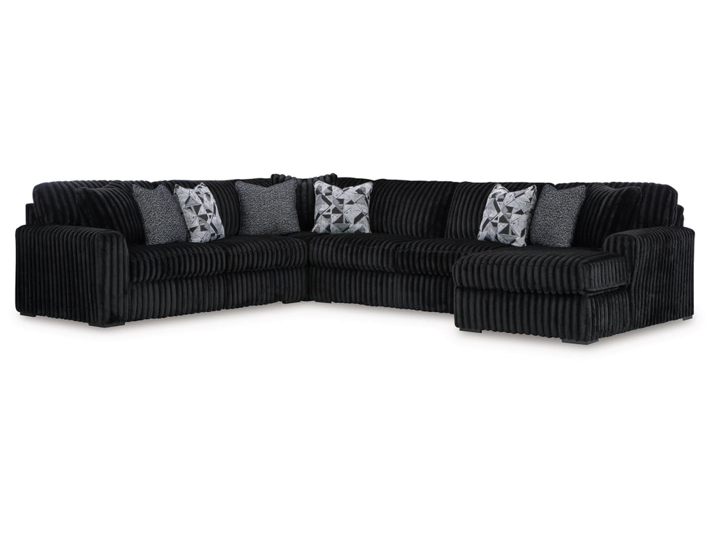Black sectional sofa with decorative pillows on a white background