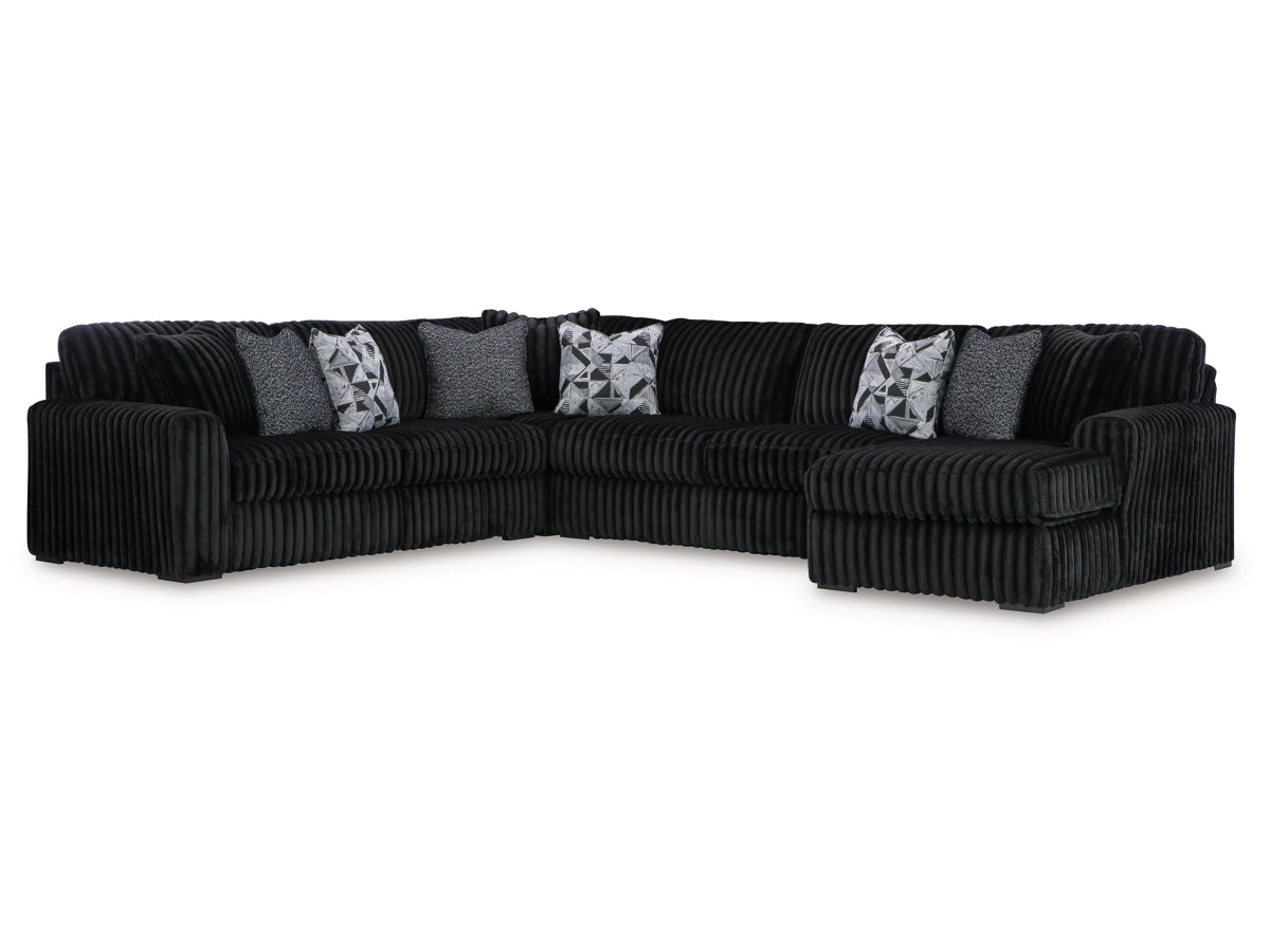 Black sectional sofa with decorative pillows on a white background