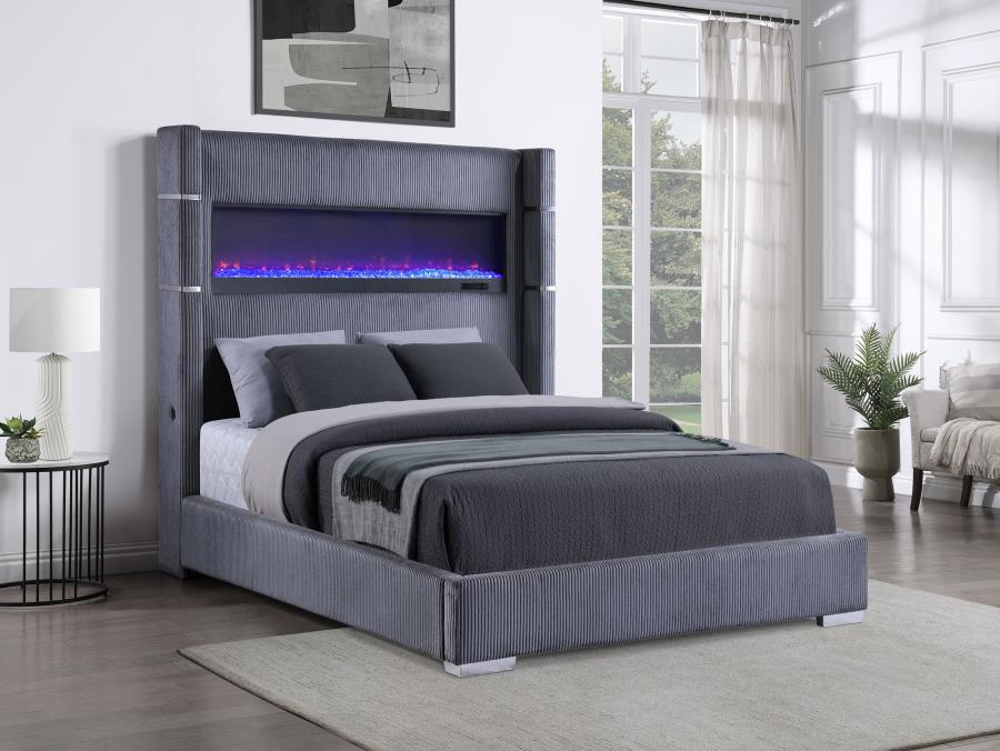 Gray upholstered bed with electric fireplace in a modern bedroom