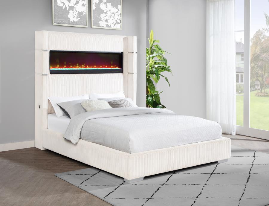White bed with built-in electric fireplace in a room with a plant and large window.