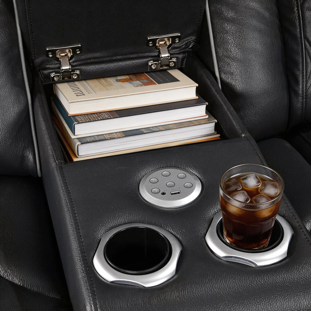 Car cup holder with a glass of iced coffee, books, and a phone on a black leather car seat.