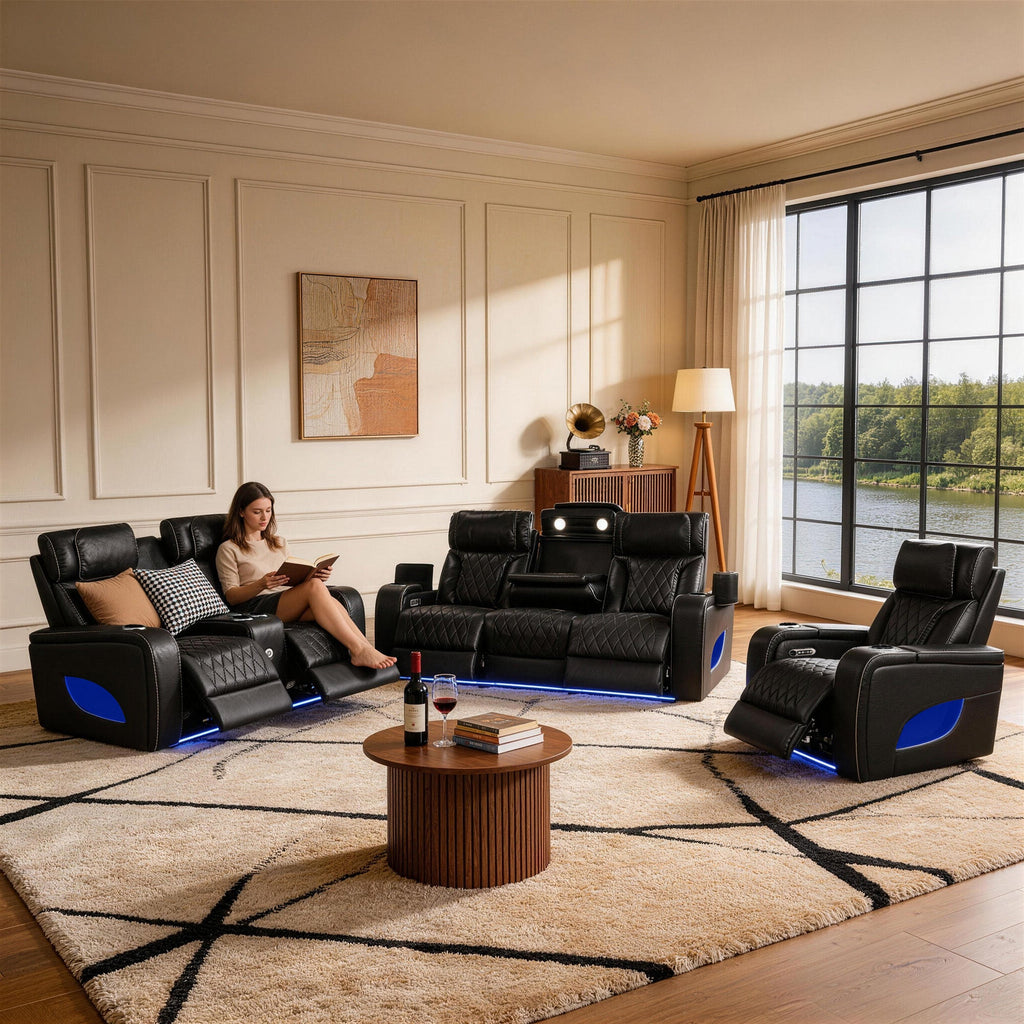 Living room with black leather recliner chairs and a woman reading a book.