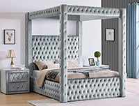 Silver tufted canopy bed in a bedroom setting with nightstands and decor.