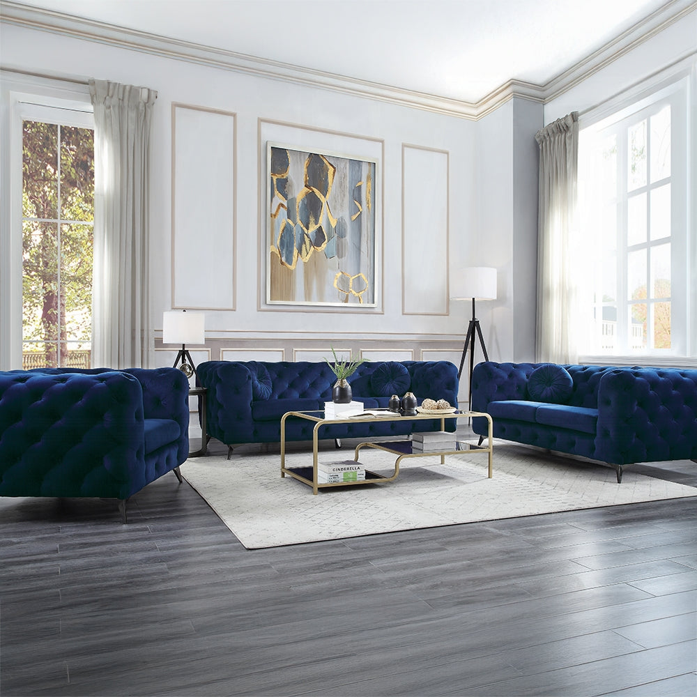 Modern living room with blue velvet sofas, gold coffee table, and abstract art on the wall.