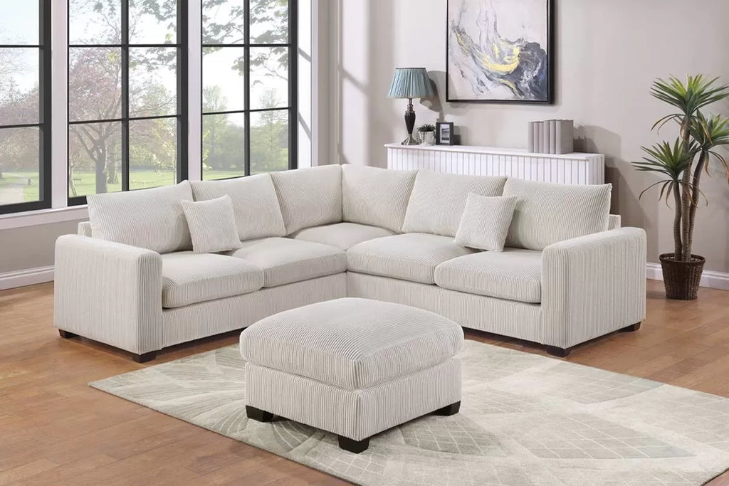 Light ivory sectional sofa with ottoman in a living room setting.