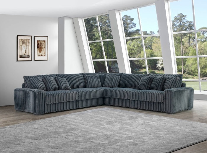 Gray sectional sofa in a room with large windows and framed pictures on the wall.