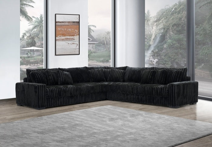 Black sectional sofa in a modern living room with large windows.