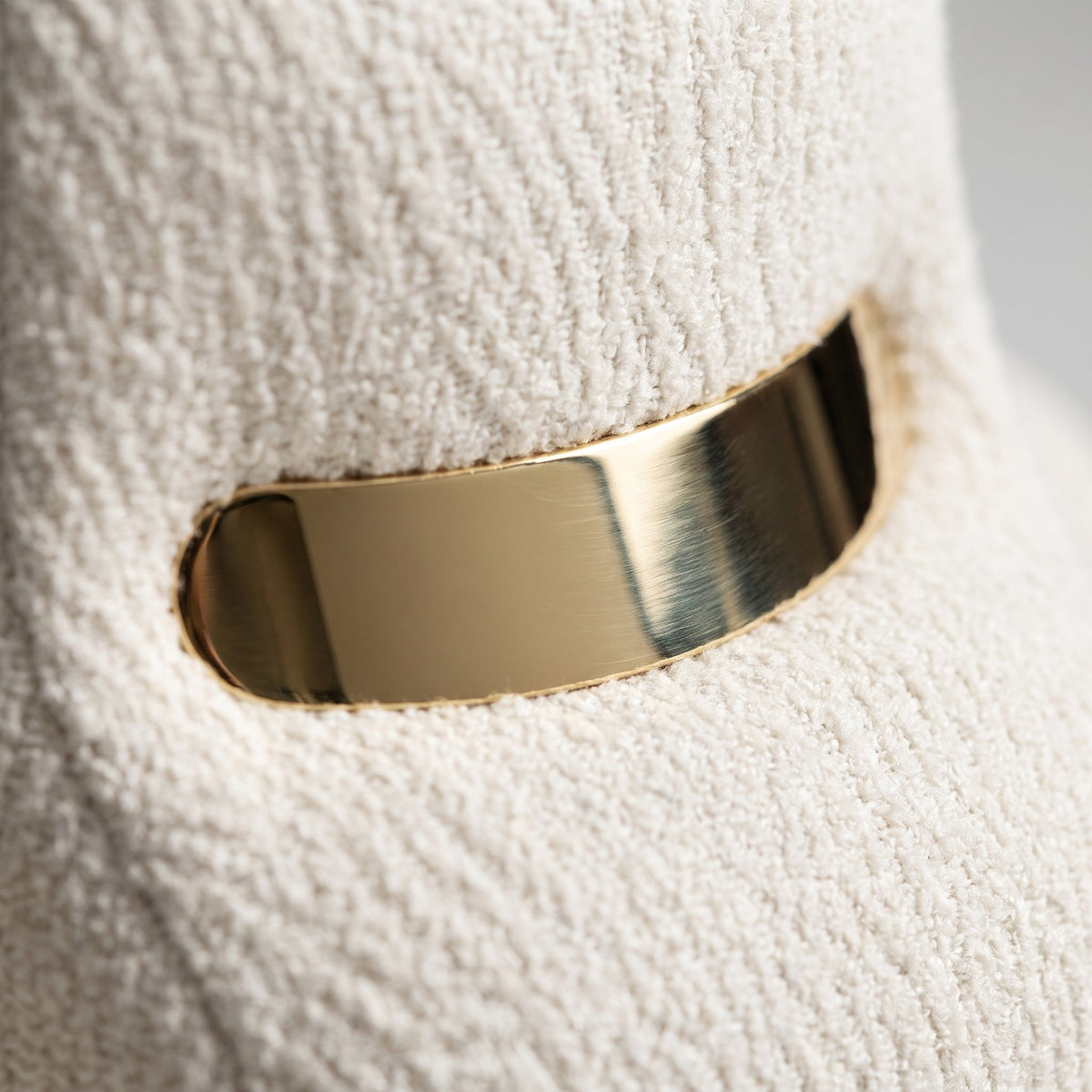 Gold bracelet on a textured white surface