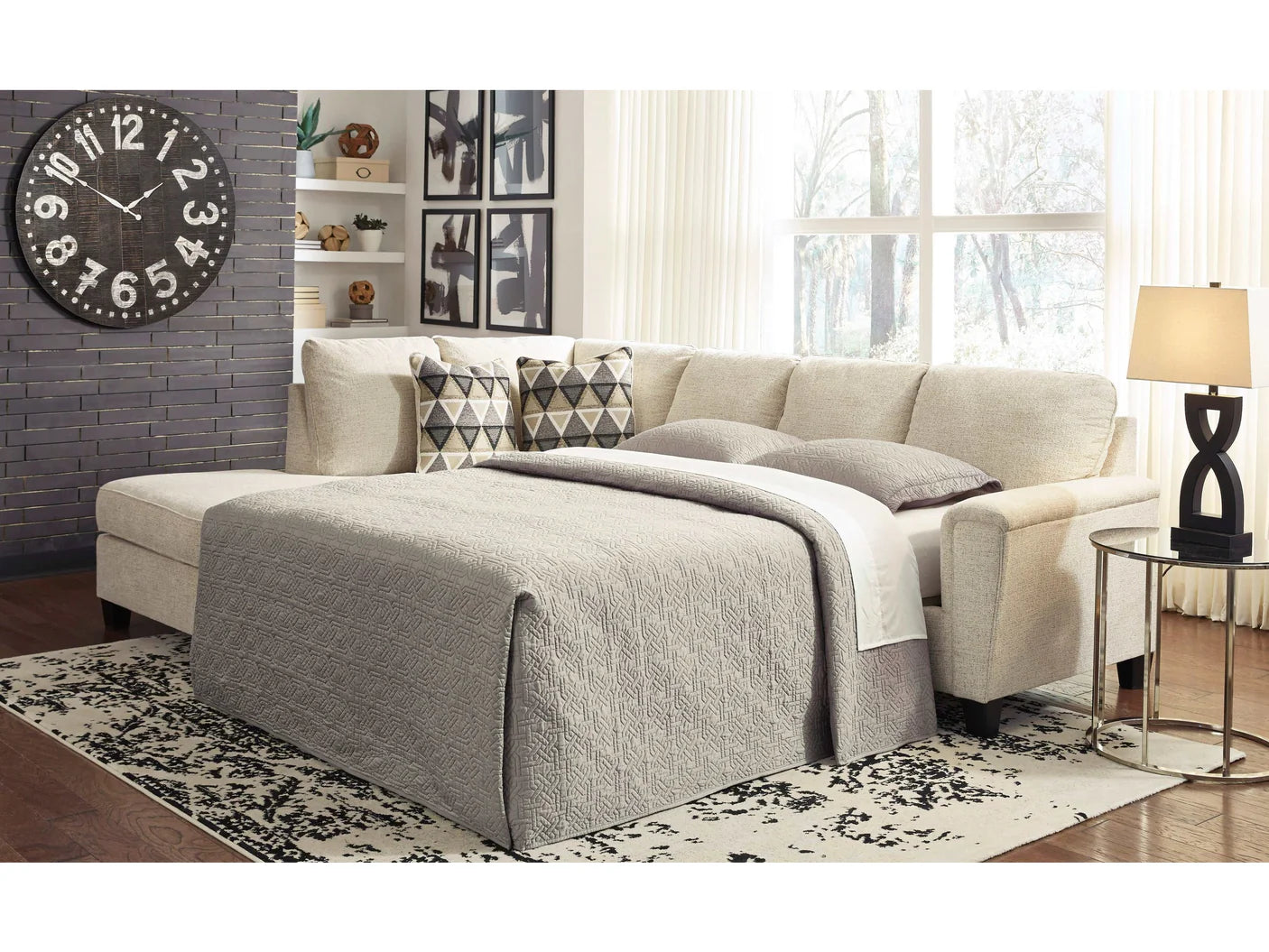 Beige sectional sofa with a blanket in a living room setting.