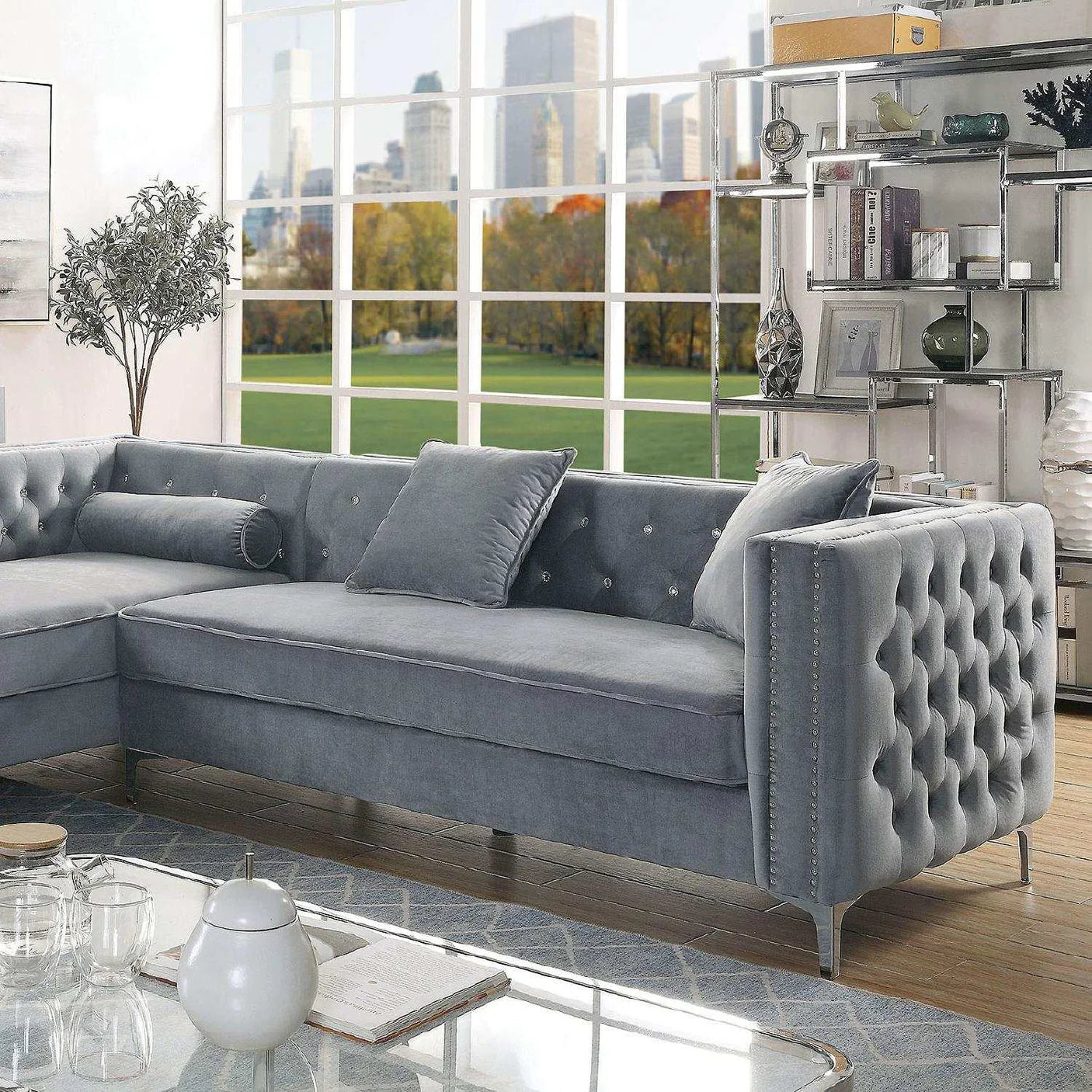 Gray sectional sofa in a living room with large windows and cityscape view.