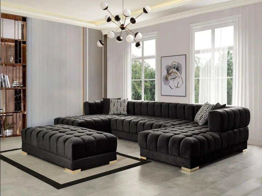Modern living room with a black tufted sectional sofa and ottoman.