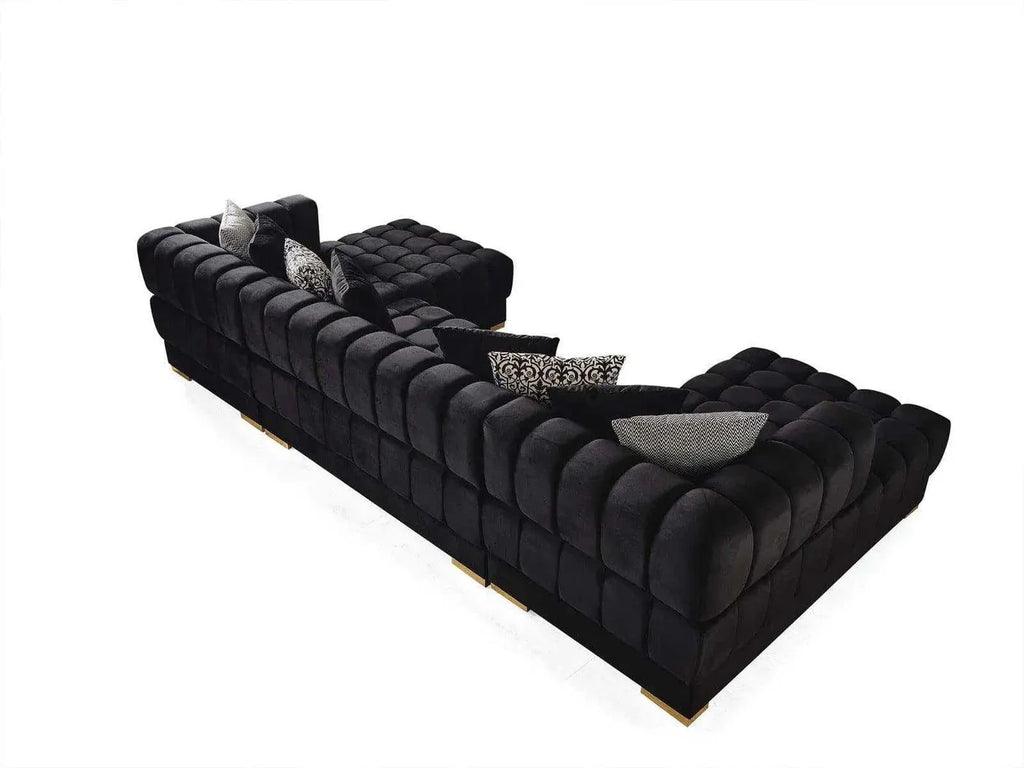 Black tufted sofa with decorative pillows on a white background
