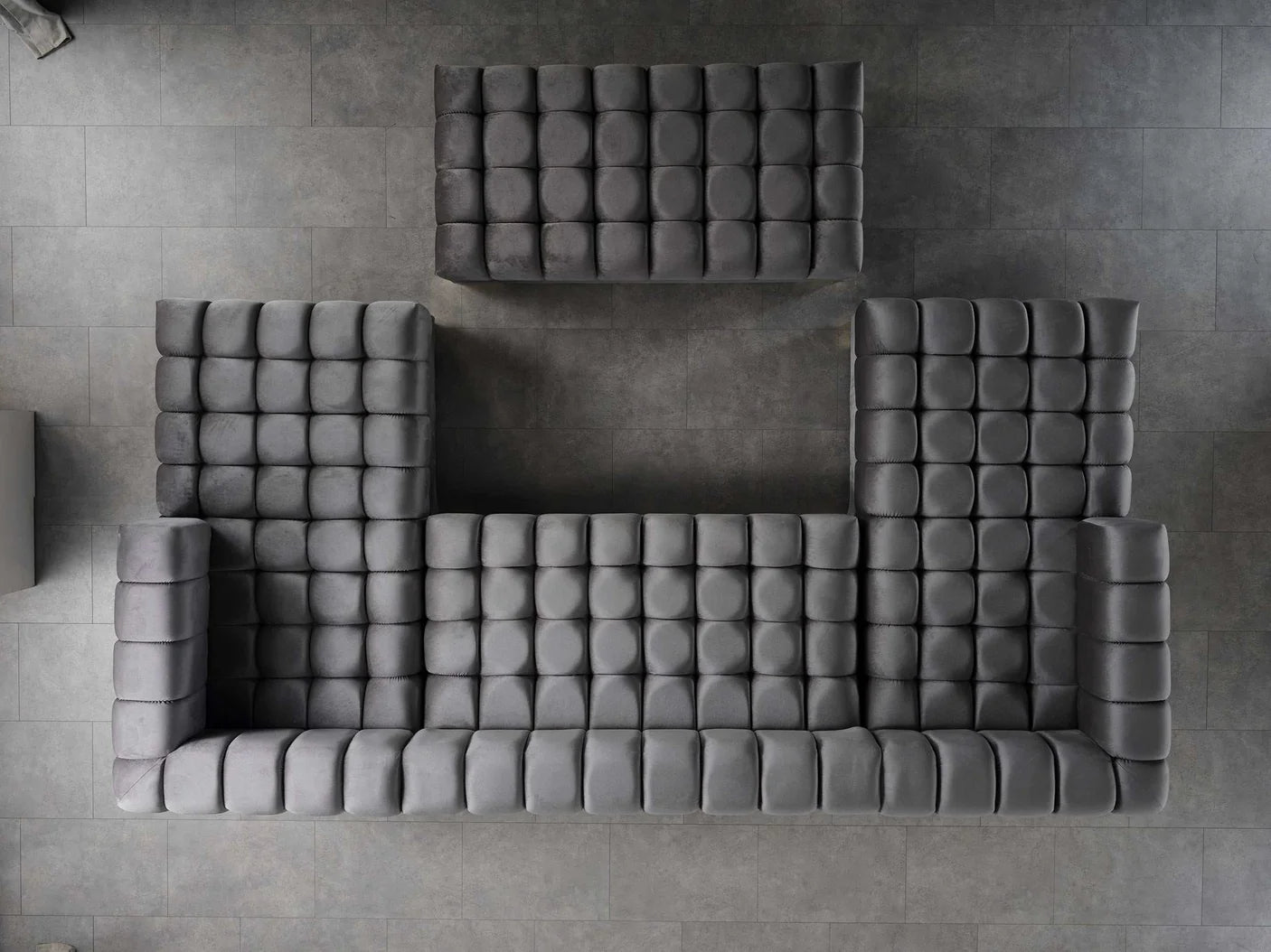 Gray tufted sofa set on a gray tiled floor
