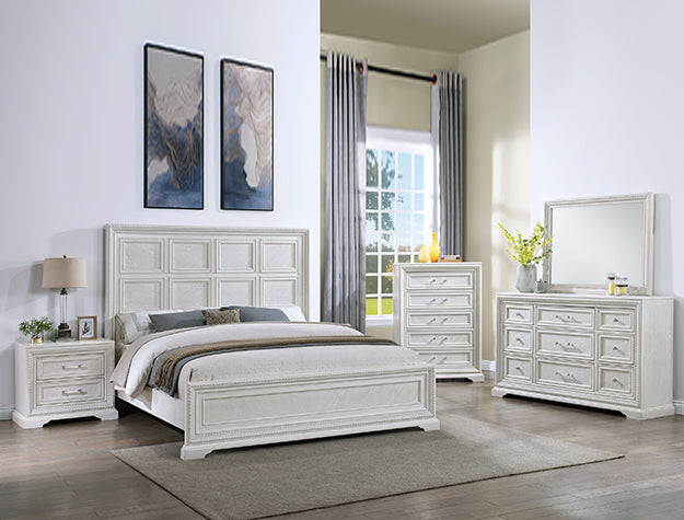 White bedroom set with bed, nightstands, dresser, and mirror in a room with large windows.