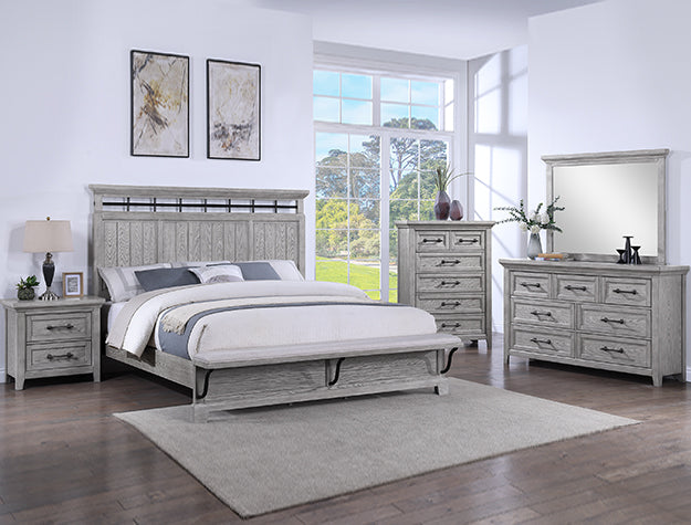 Gray bedroom furniture set with bed, nightstands, dresser, and mirror in a bright room.