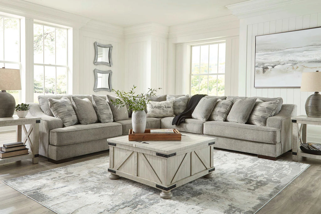 Living room with gray sectional sofa, coffee table, and decorative elements.