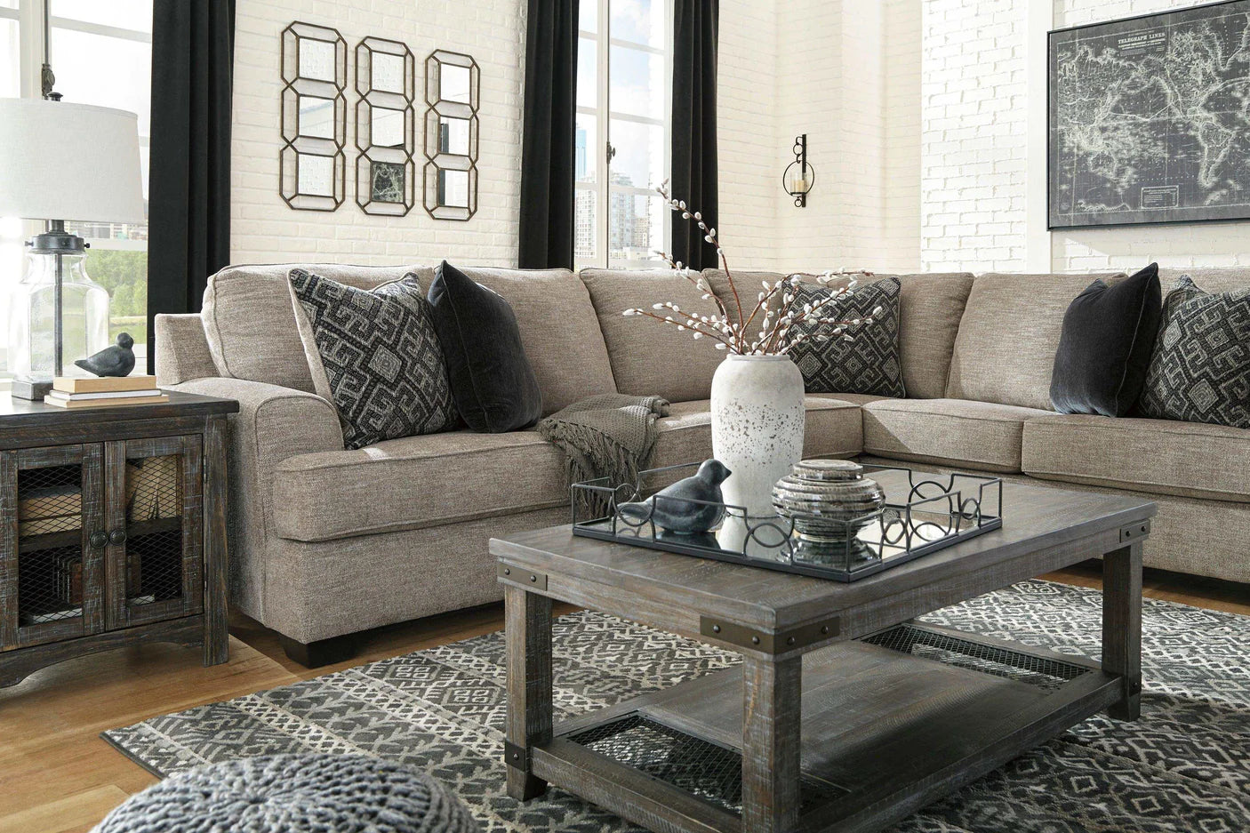 Living room with a gray sectional sofa, wooden coffee table, and decorative elements.