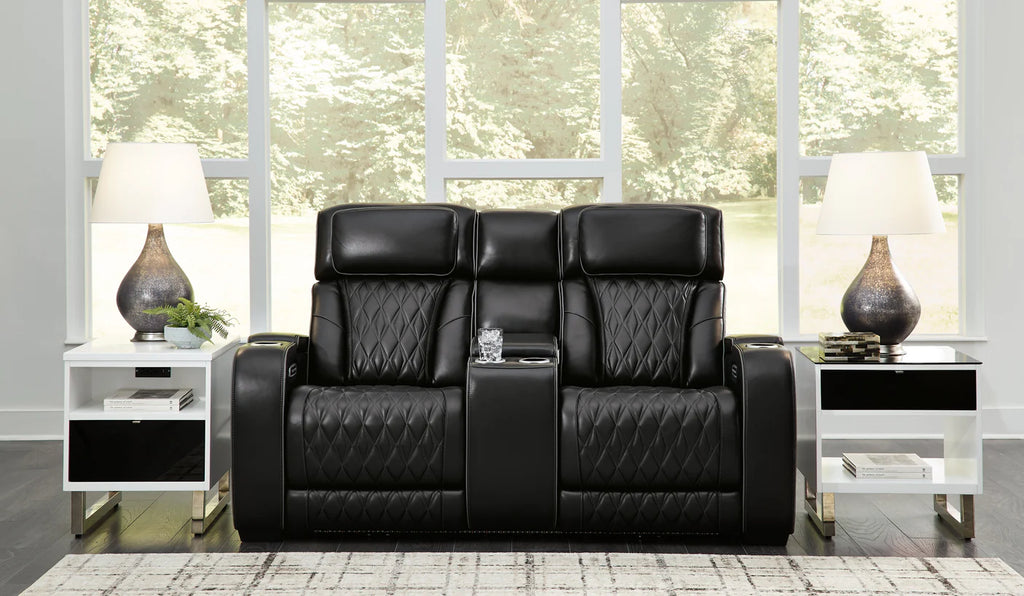 Black reclining loveseat with cupholders set in a modern living room.