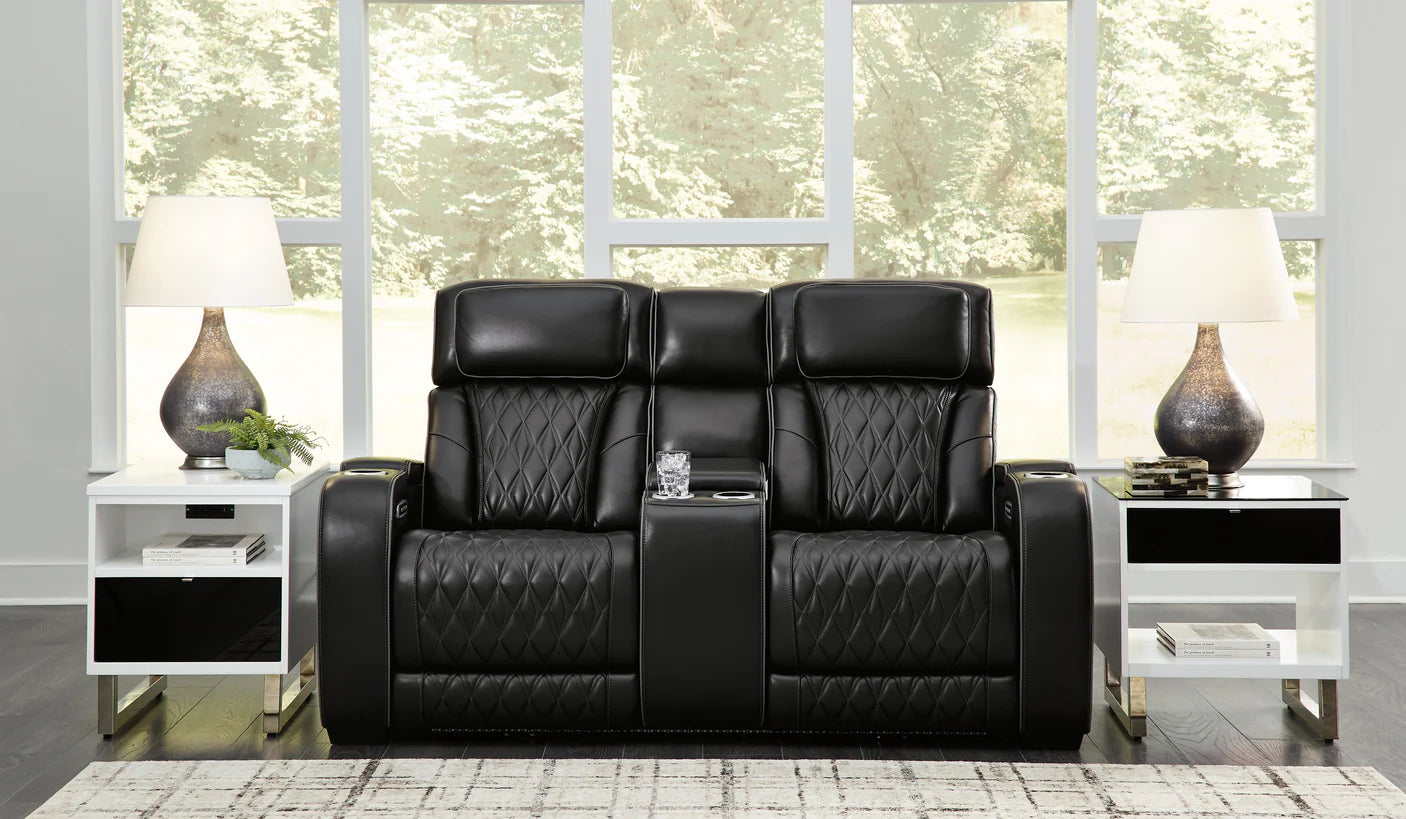 Black reclining loveseat with cupholders set in a modern living room.