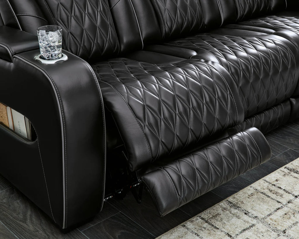 Close up of foot rest on a black leather couch.