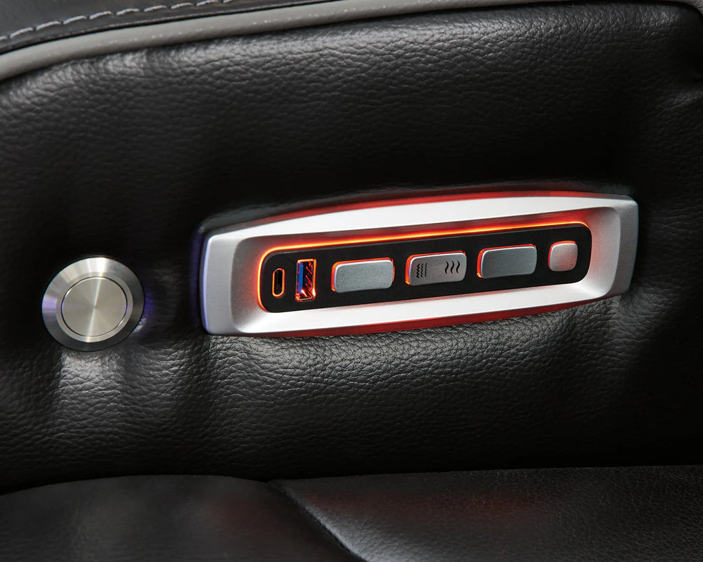 Close up of the power settings on a black leather couch.