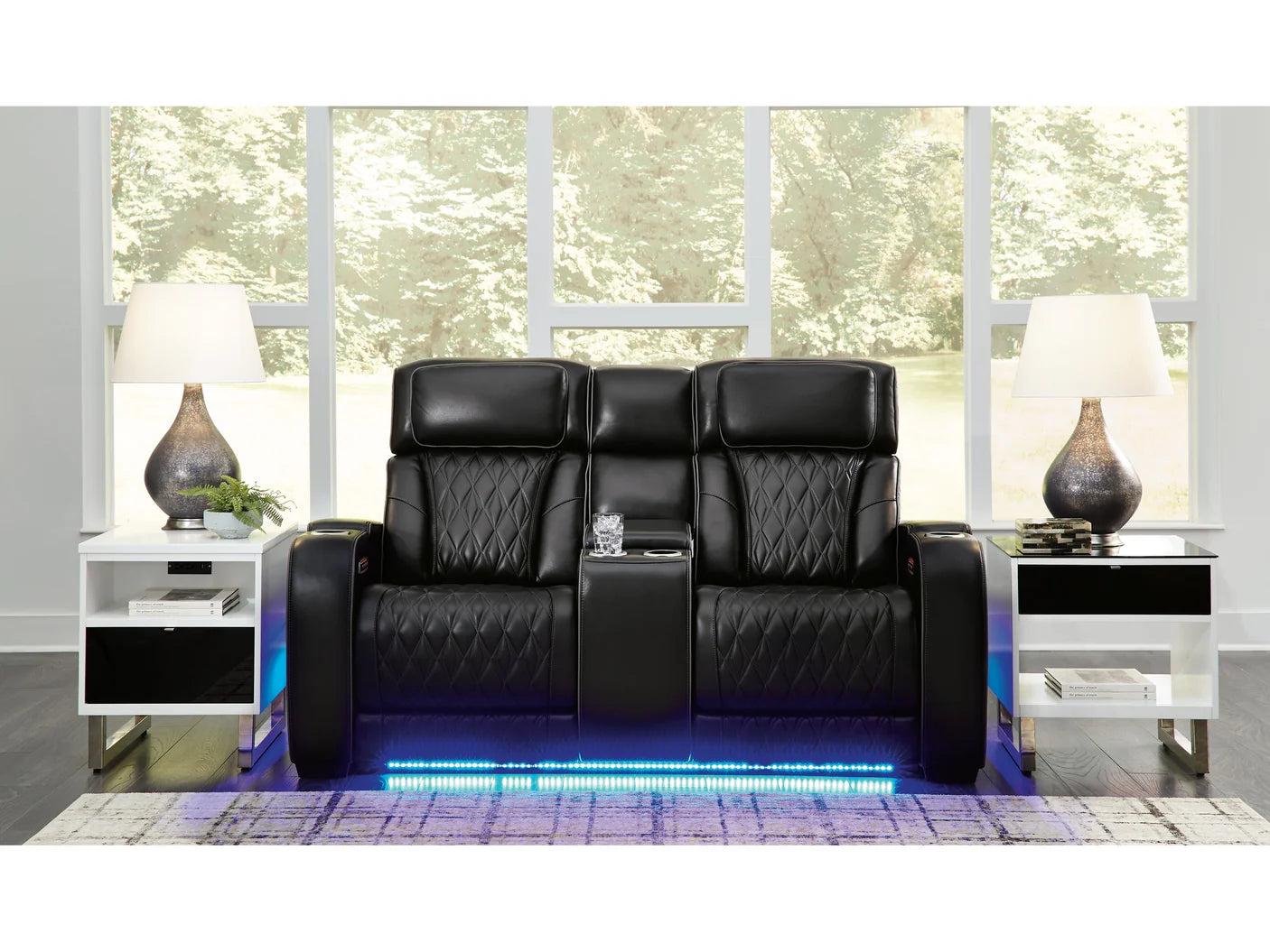 Black reclining loveseat with cupholders and LED lighting set in a modern living room.