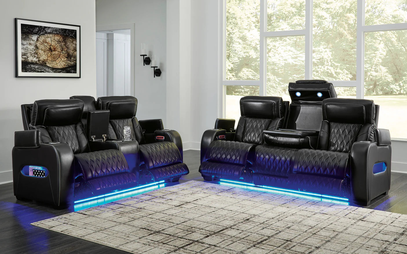 Black reclining sofa loveseat with blue led lighting and storage compartments set in a modern living room.