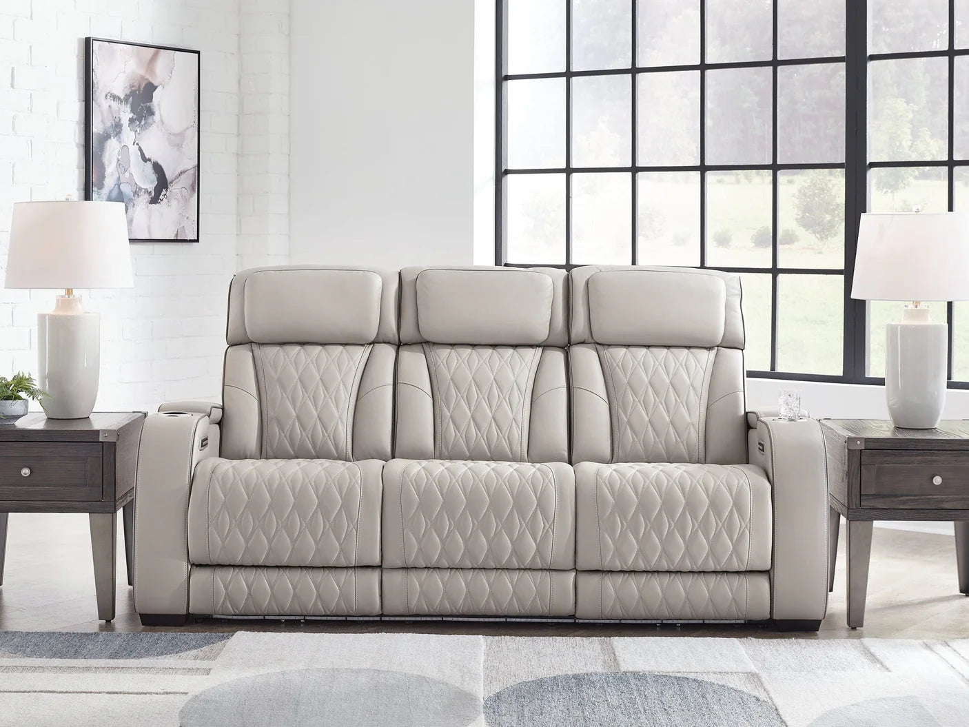 Gray sofa in a modern living room with large windows.