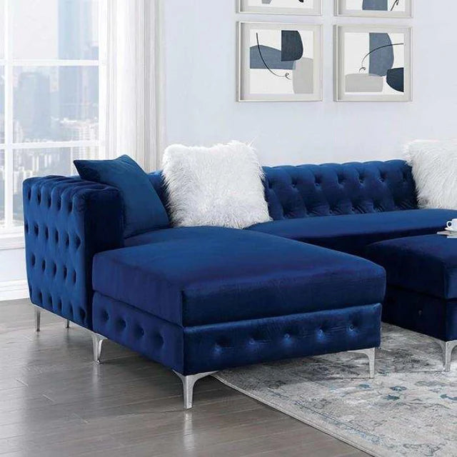 Blue tufted sectional sofa in a living room with abstract art on the wall.