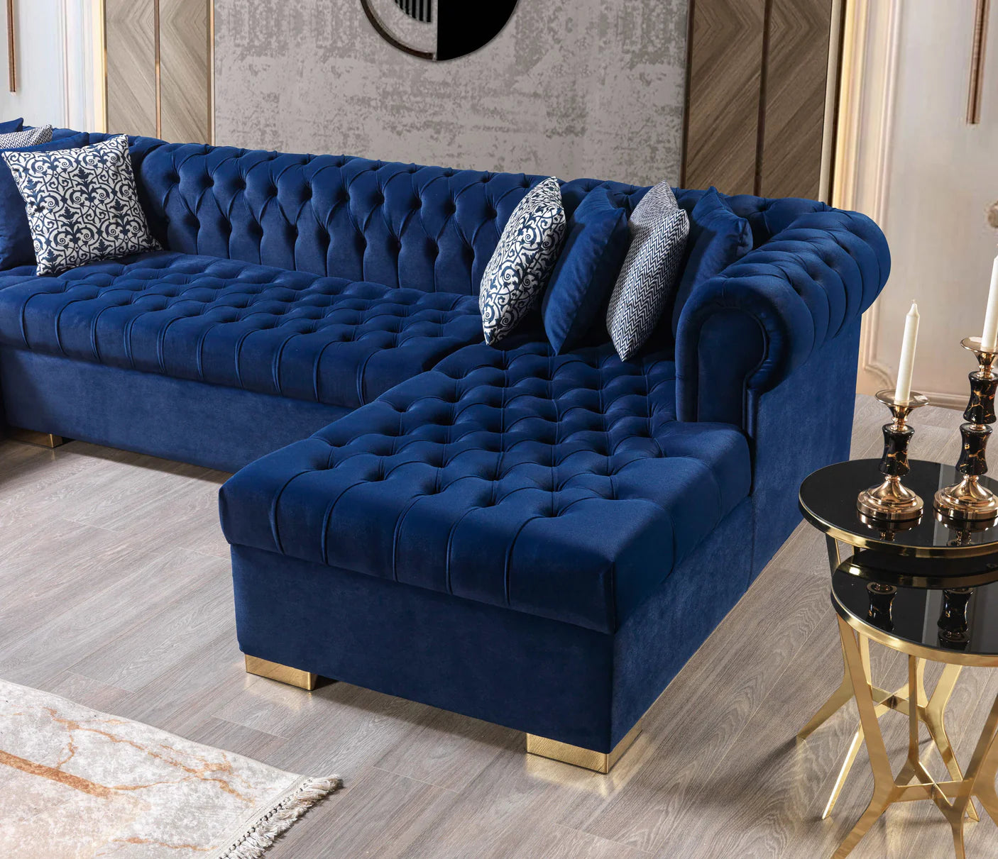 Blue tufted sofa in a living room setting with decorative pillows and a small table.