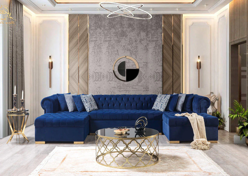 Modern living room with a blue sectional sofa, gold coffee table, and decorative wall art.