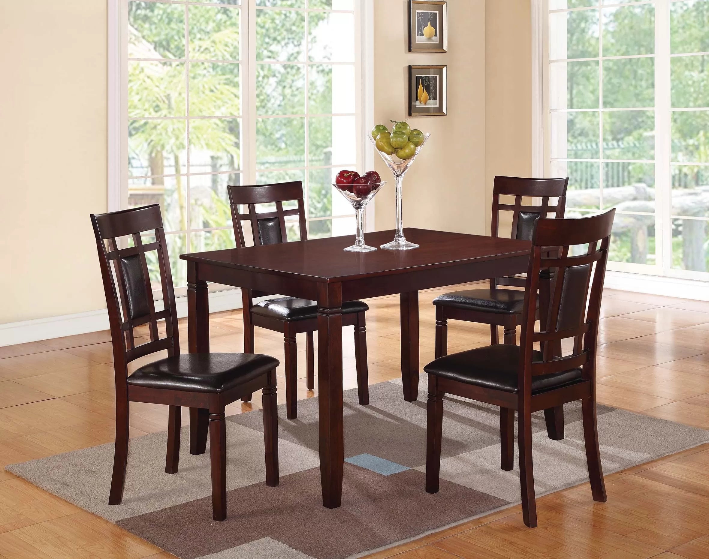 Dining room set with a table and four chairs on a wooden floor.