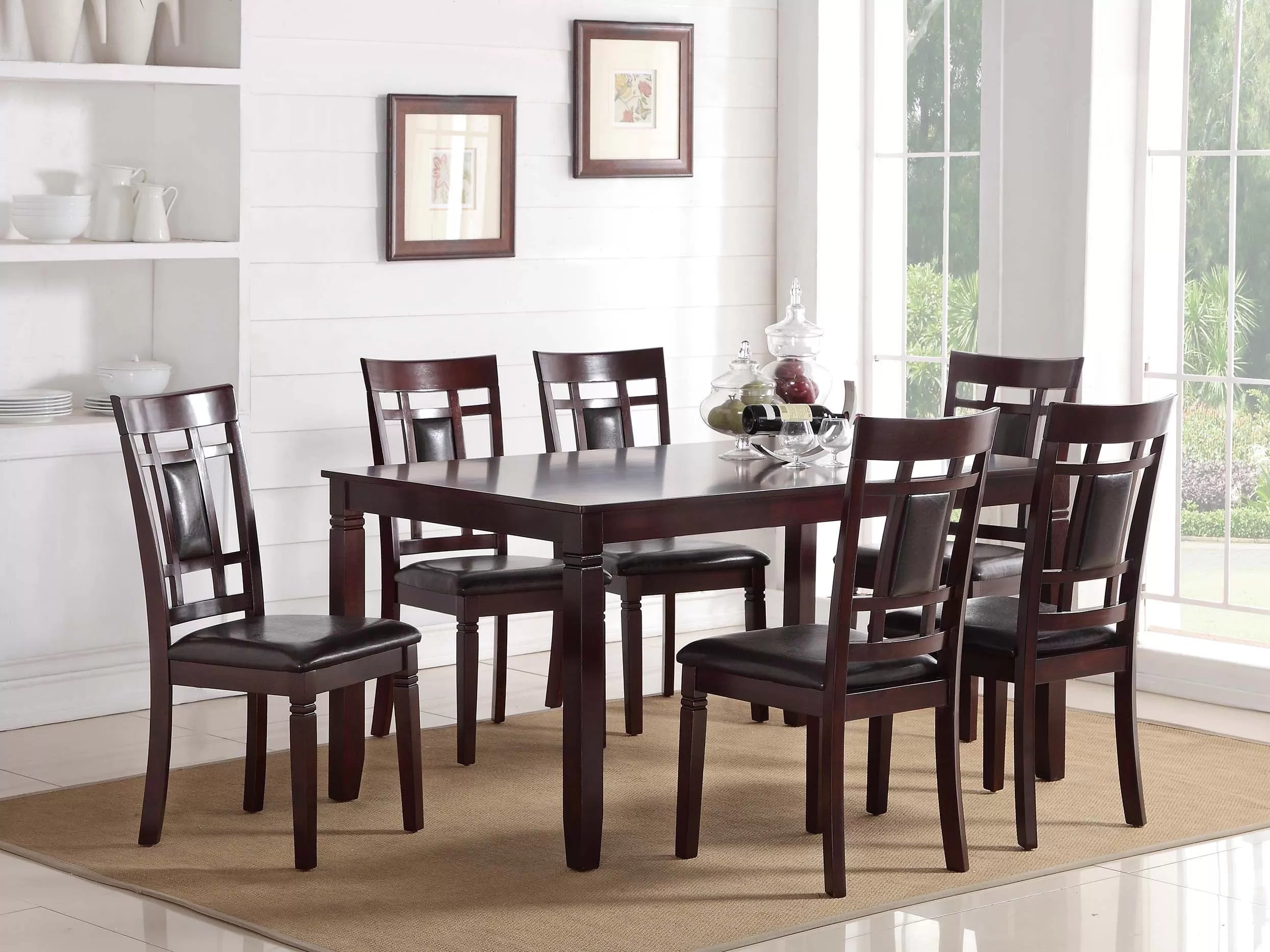 Dining room with a dark wood table and chairs in a well-lit room.