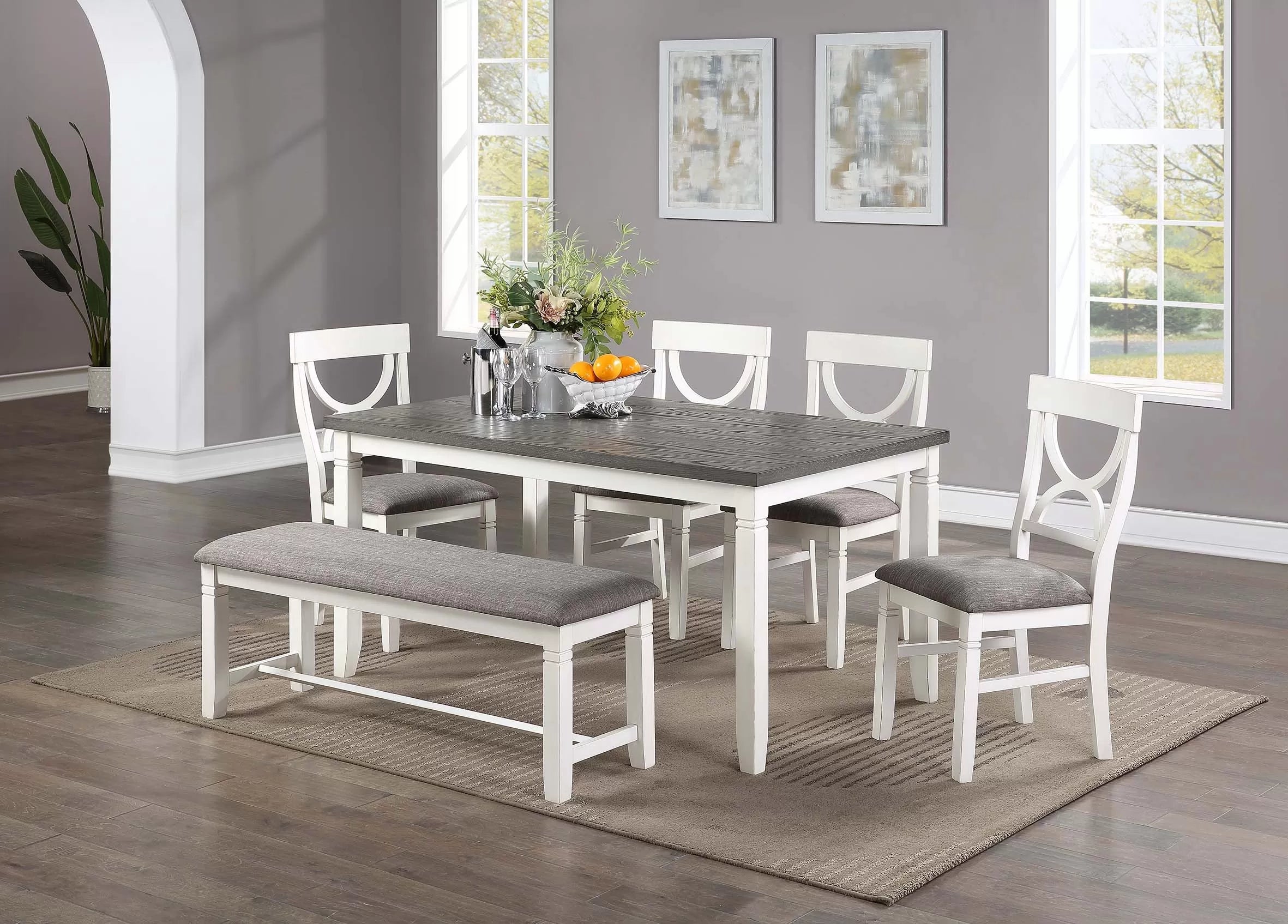 Dining room set with table, chairs, and bench on a wooden floor.