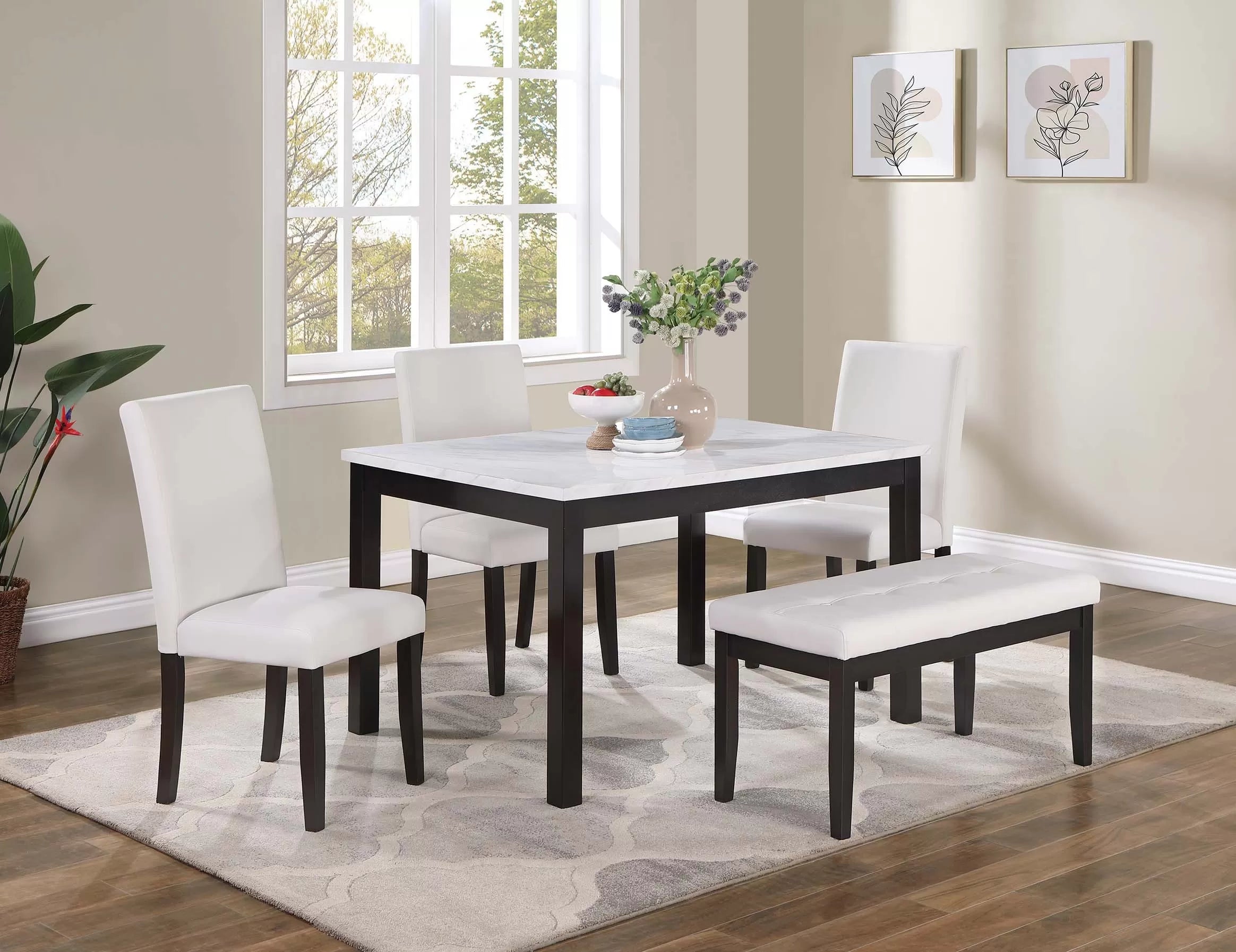 Dining room set with a black table and white chairs and bench on a wooden floor.