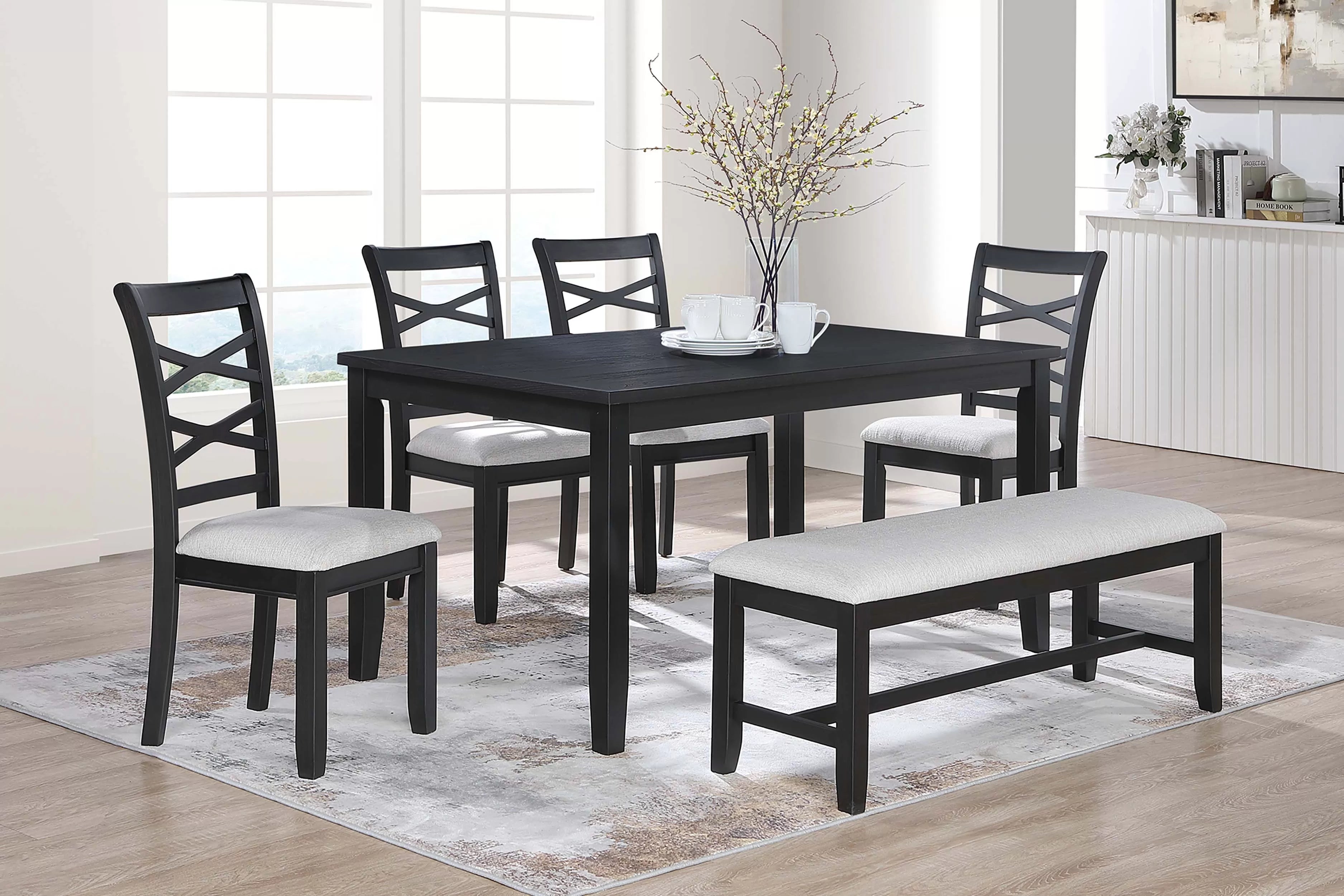 Dining room set with black table and chairs on a wooden floor.