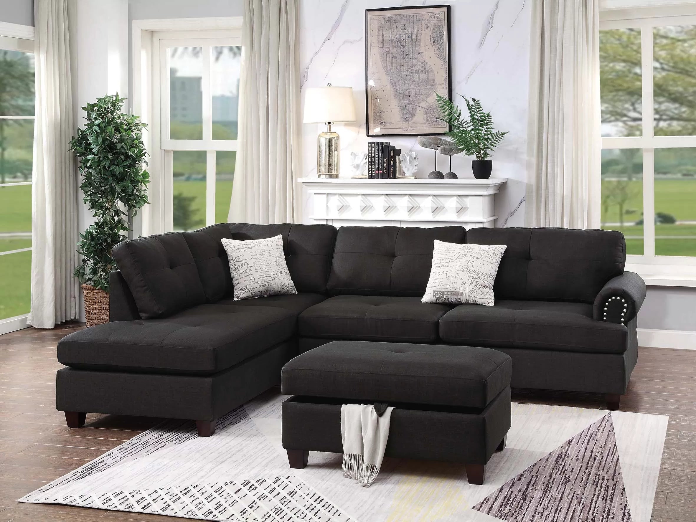 Black sectional sofa in a living room with a rug, ottoman, and decorative items.