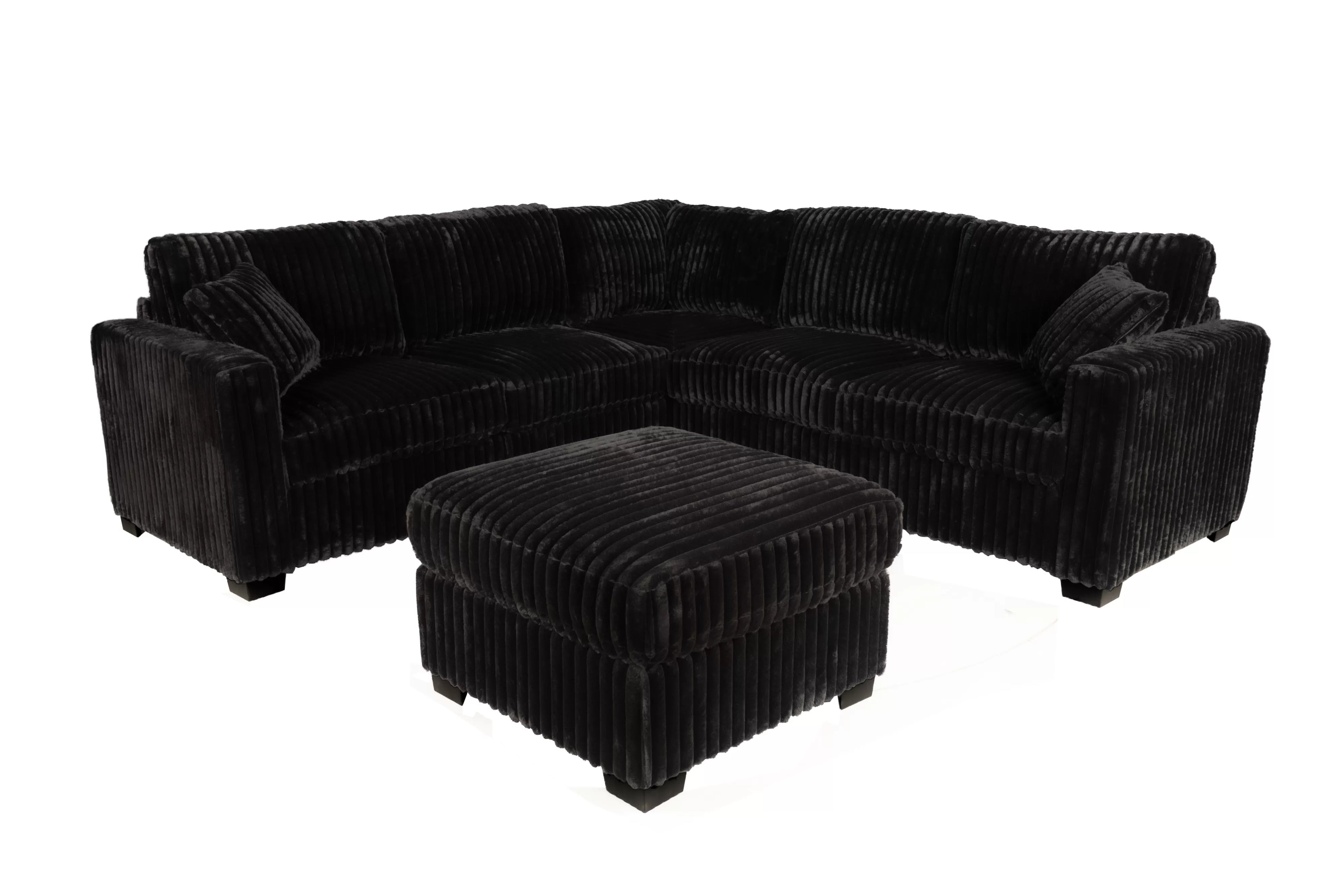 Black corduroy sectional sofa with matching ottoman on a white background