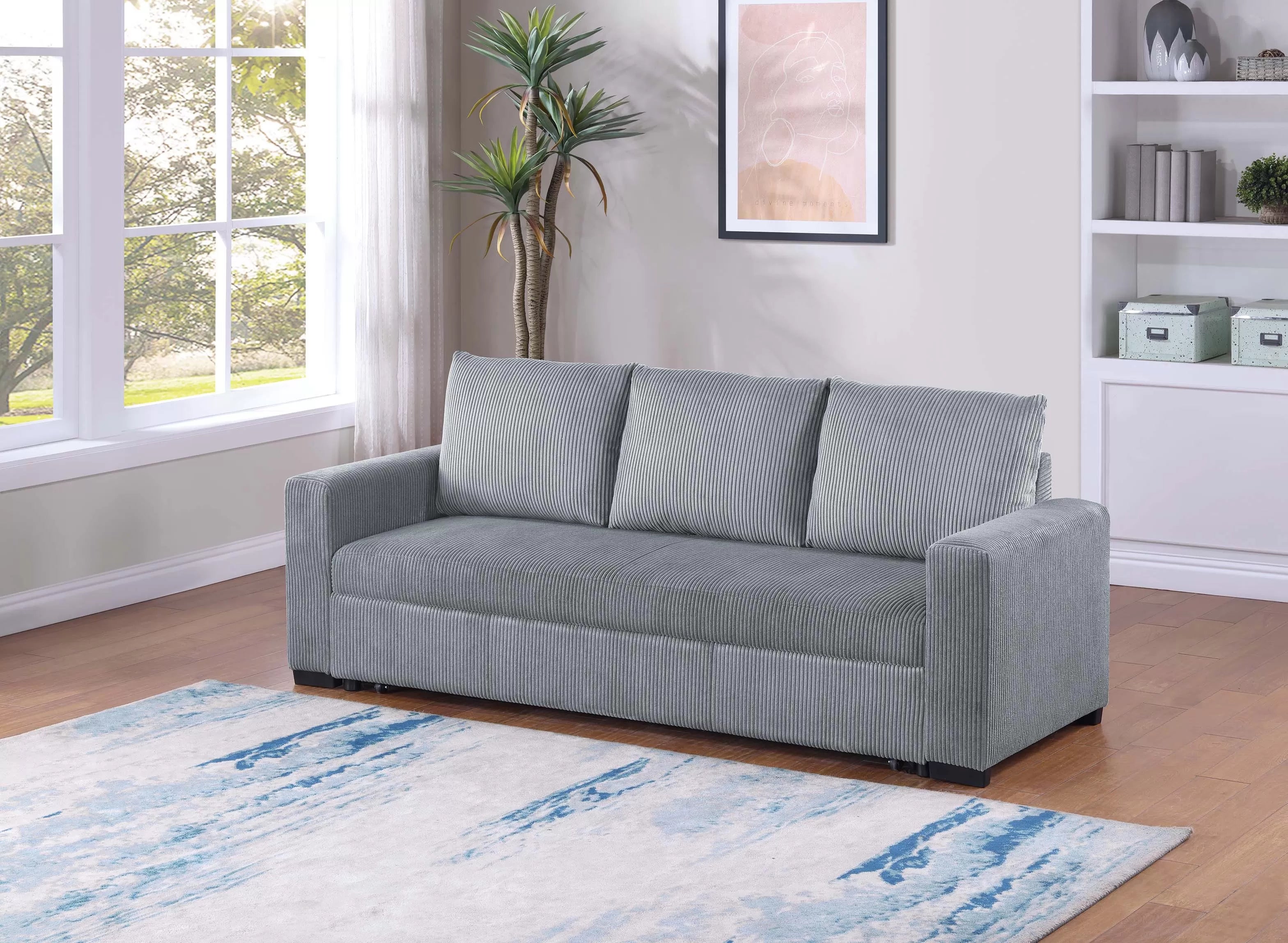 Gray sofa in a living room with a rug and window
