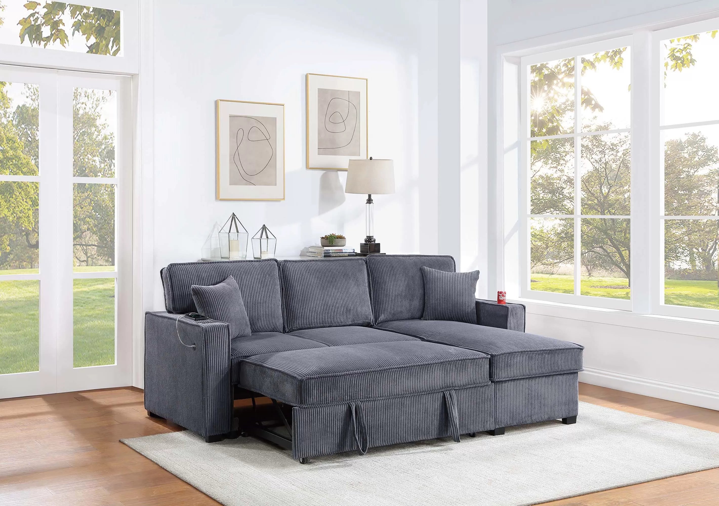 Gray sectional sofa in a living room with large windows and decor.