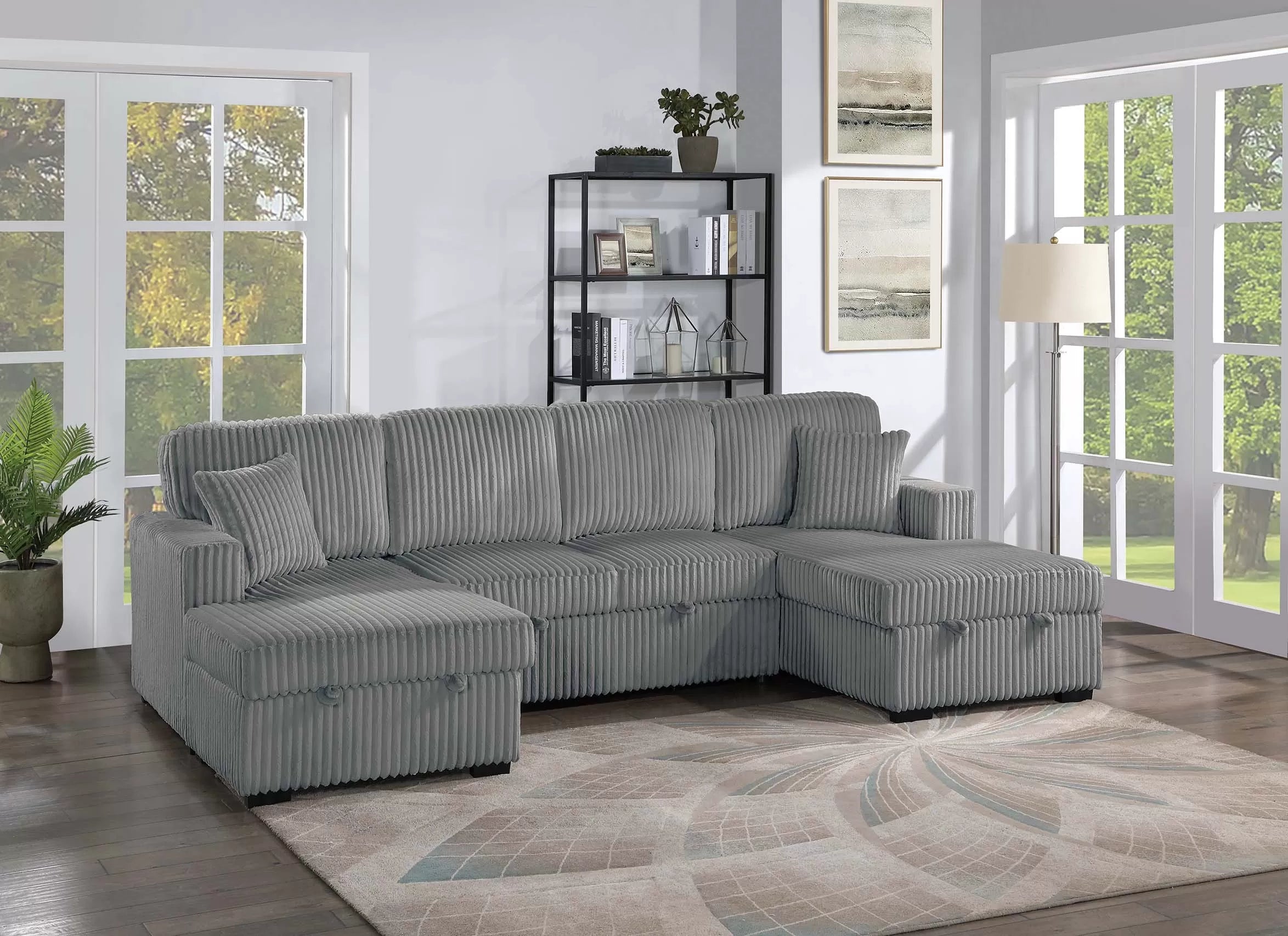 Gray sectional sofa in a living room with large windows and decor.