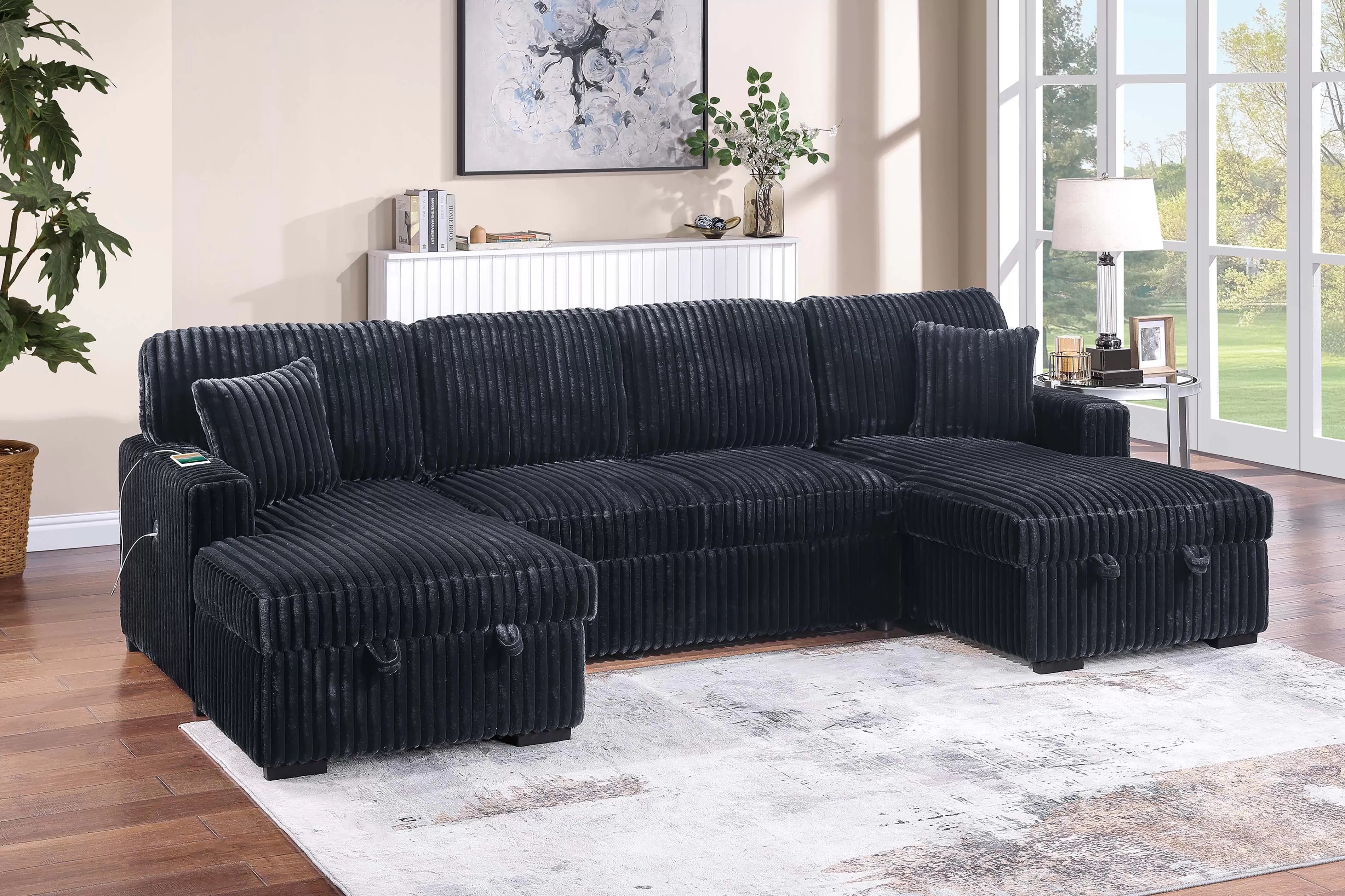 Black sectional sofa in a living room setting with decor elements.