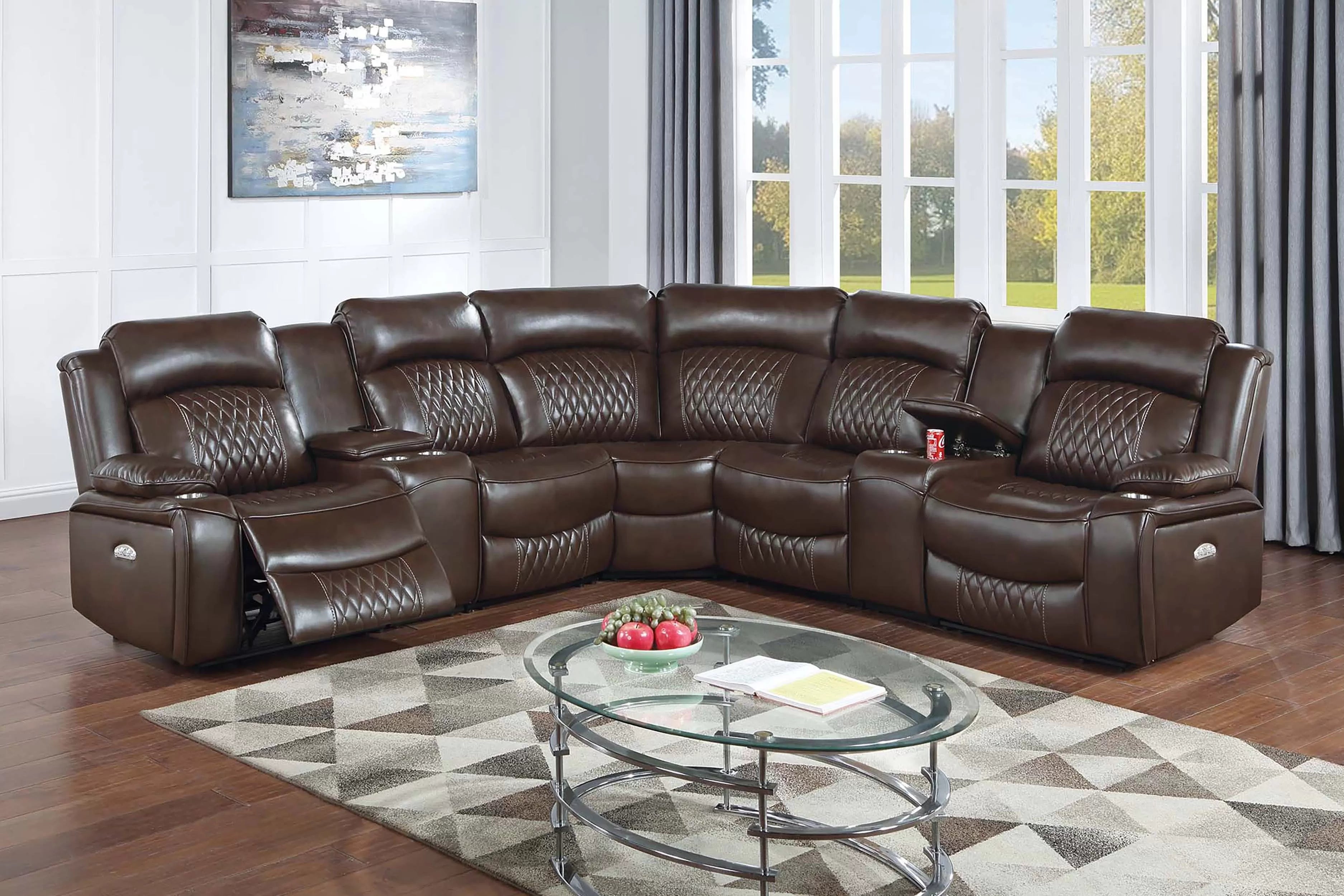 Brown leather sectional sofa in a living room with a glass coffee table and decorative items.