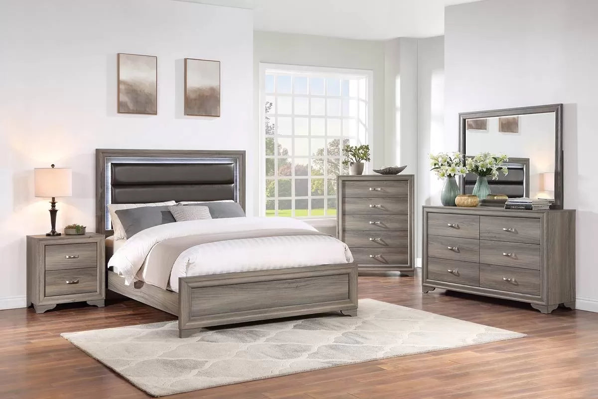 Gray bedroom set with bed, nightstands, dresser, and mirror in a room with large windows.