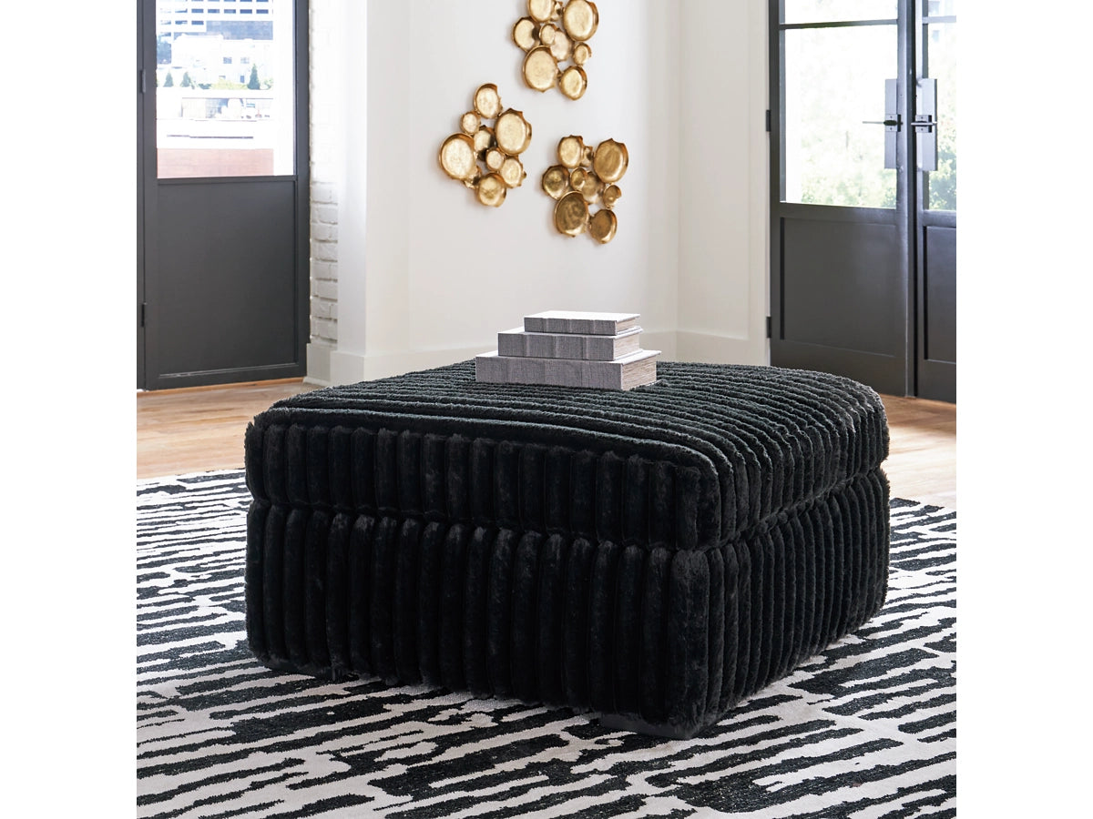 Black textured ottoman in a room with decorative elements