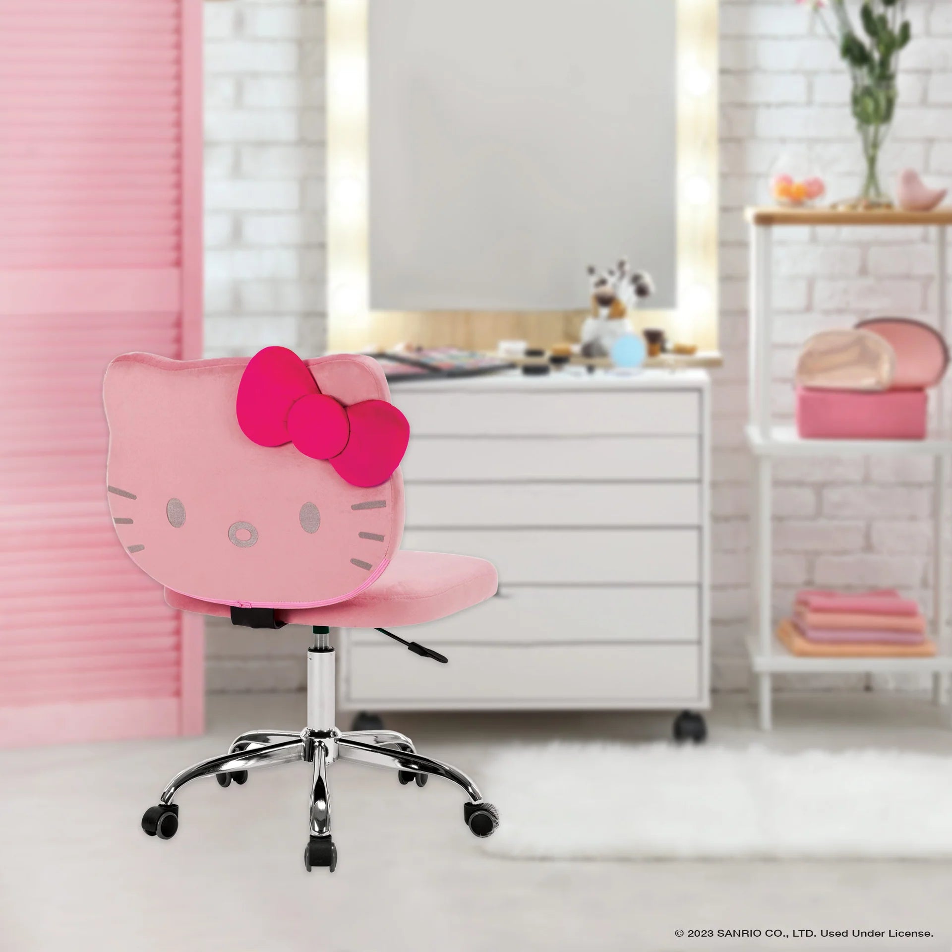 Pink Hello Kitty chair in a room with a white dresser and pink decor.