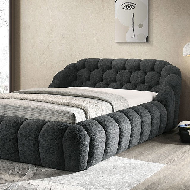 Modern bedroom with a gray upholstered bed and abstract art on the wall.
