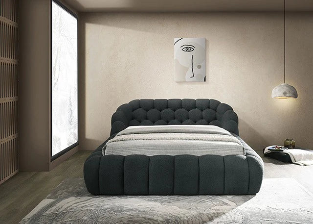 Modern bedroom with a gray upholstered bed and abstract wall art.